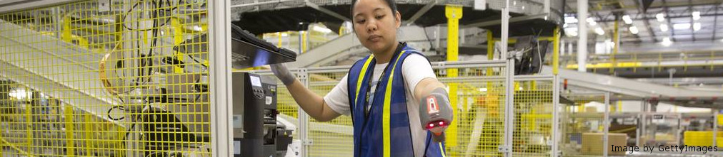 Amazon employee scanning boxes on the conveyor tape of the fulfillment center