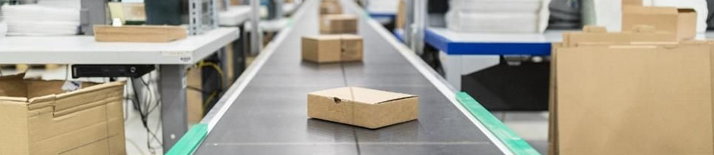 Cardboard boxes moving on transporter tape in Amazon fulfillment center