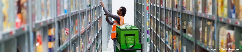 Amazon employee sorting packages on the shelf of fulfilment center