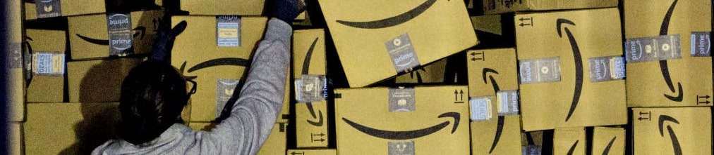 employee taking a cardboard box from the shelf at Amazon fulfilment center