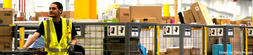 Amazon employee drives trolleys with carton boxes on them