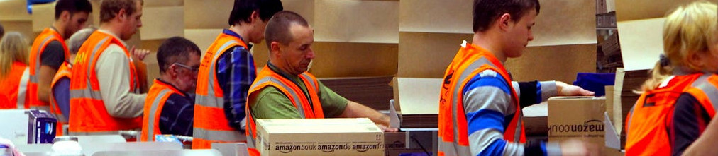 Employees in orange vests sorting boxes in Amazon fulfillment center