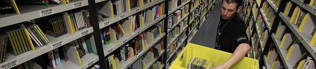 Amazon employee sorting boxes on the shelves of fulfilment center