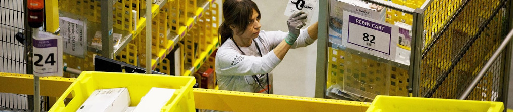 Amazon employee sorting boxes in fulfillment center
