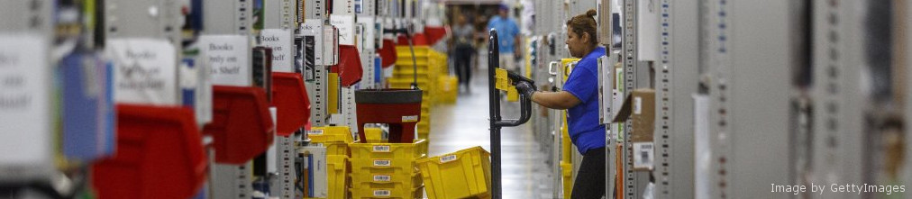 Amazon employee pushing cart in fulfillment center
