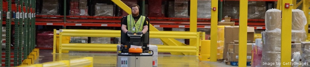 Amazon employee driving forklift in fulfilment center