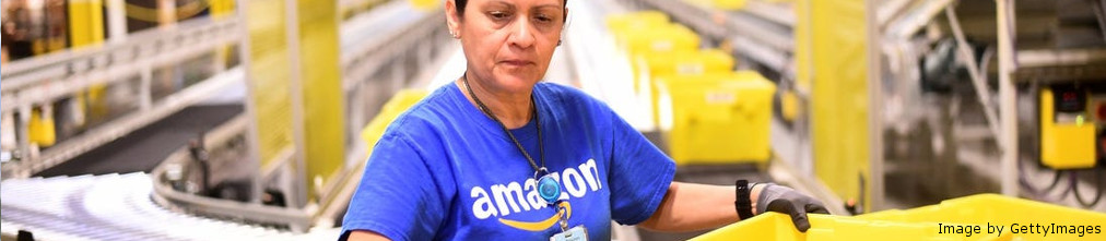 employee in t shirt with Amazon logo scanning packages
