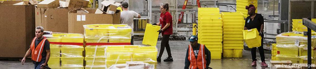 Amazon emproyees moving yellow boxes