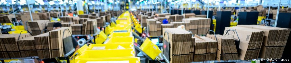 Yellow packages moving on transporter tape in Amazon fulfillment center