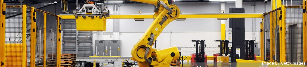 Automated robot hand moving yellow boxes in Amazon fulfillment center