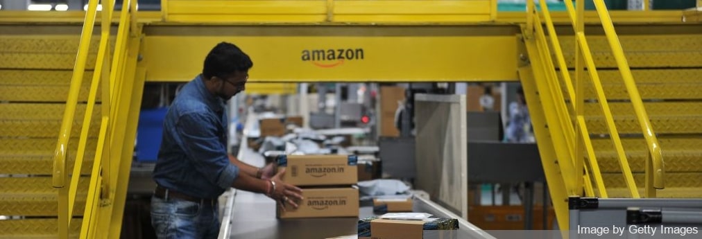 Amazon employee sorting boxes on a conveyor belt of Amazon fulfillment center