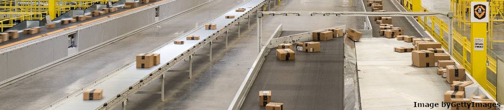Boxes with Amazon Prime stickers moving on various conveyor belt in Amazon fulfillment center