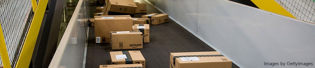 boxes with Amazon stickers moving on transporter tape in the fulfillment center
